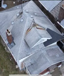 A long shot of the damaged roof of the house
